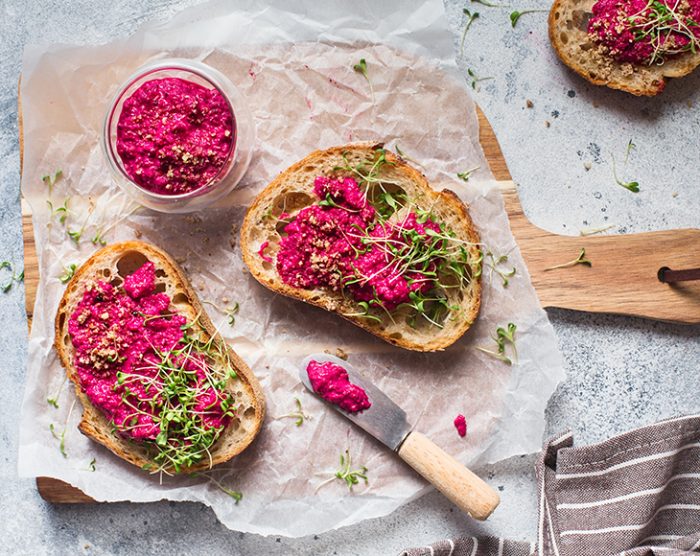Bruschetta with Beetroot hummus decorated with chopped nuts and