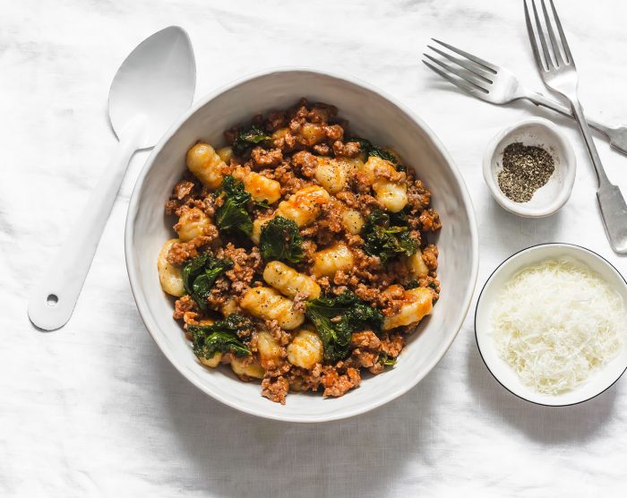 Gnocchi potatoes with turkey bolognese sauce and kale on a light